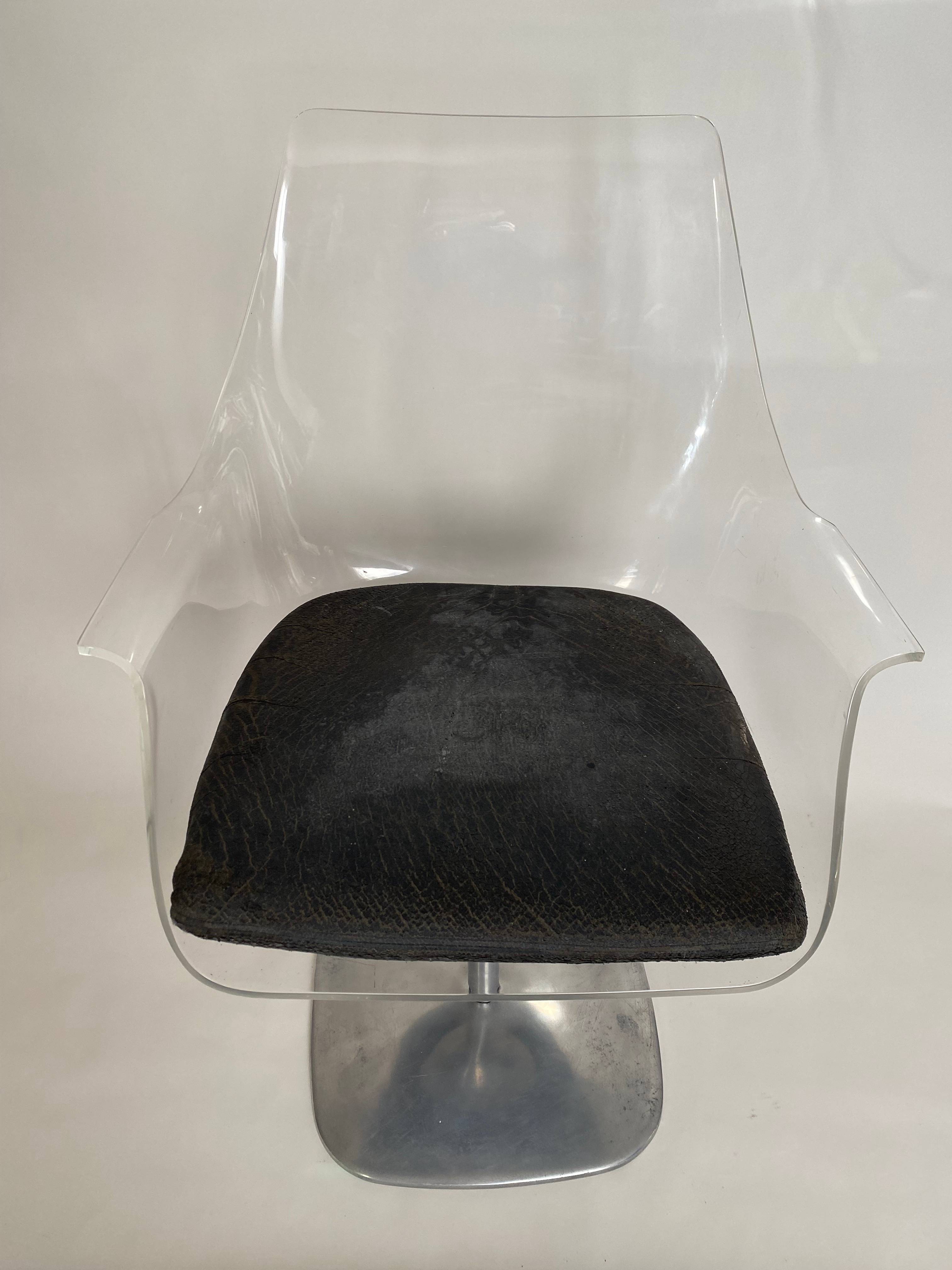 Chaise en plexiglas reposant sur un piètement rotatif en métal