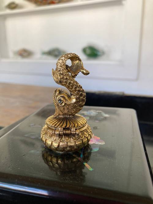 Petite boite en métal doré , surmontée d’un dauphin aux yeux de verre bleu